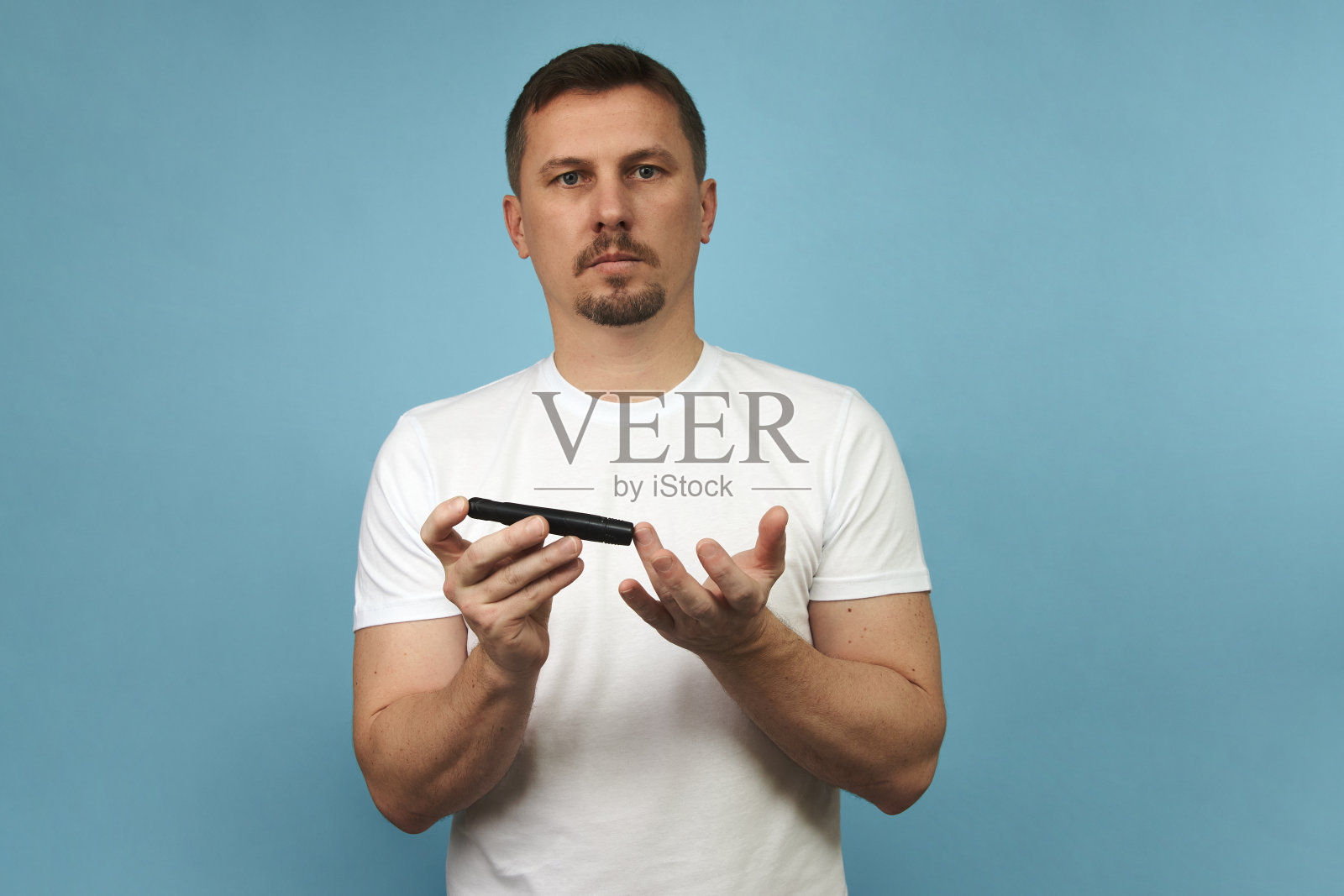 拿着柳叶刀笔做糖尿病检查的人，特写照片摄影图片