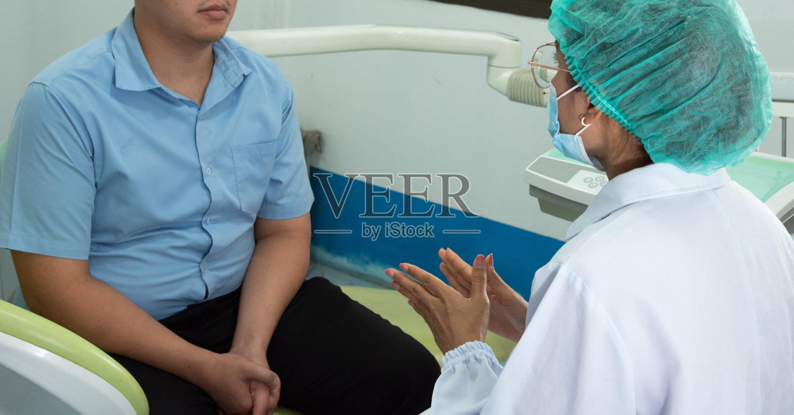 牙医在牙科诊所向病人讲解，进行牙科保健咨询。照片摄影图片