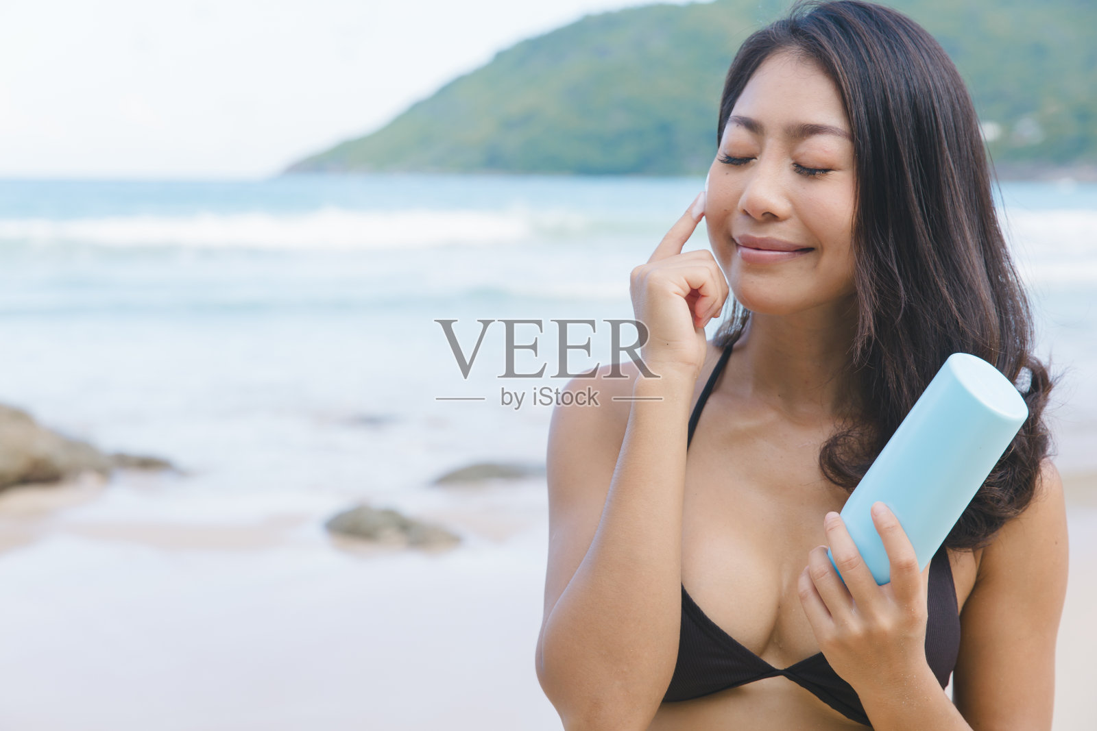 海上阳光安全:穿着比基尼的女游客使用防晒霜照片摄影图片