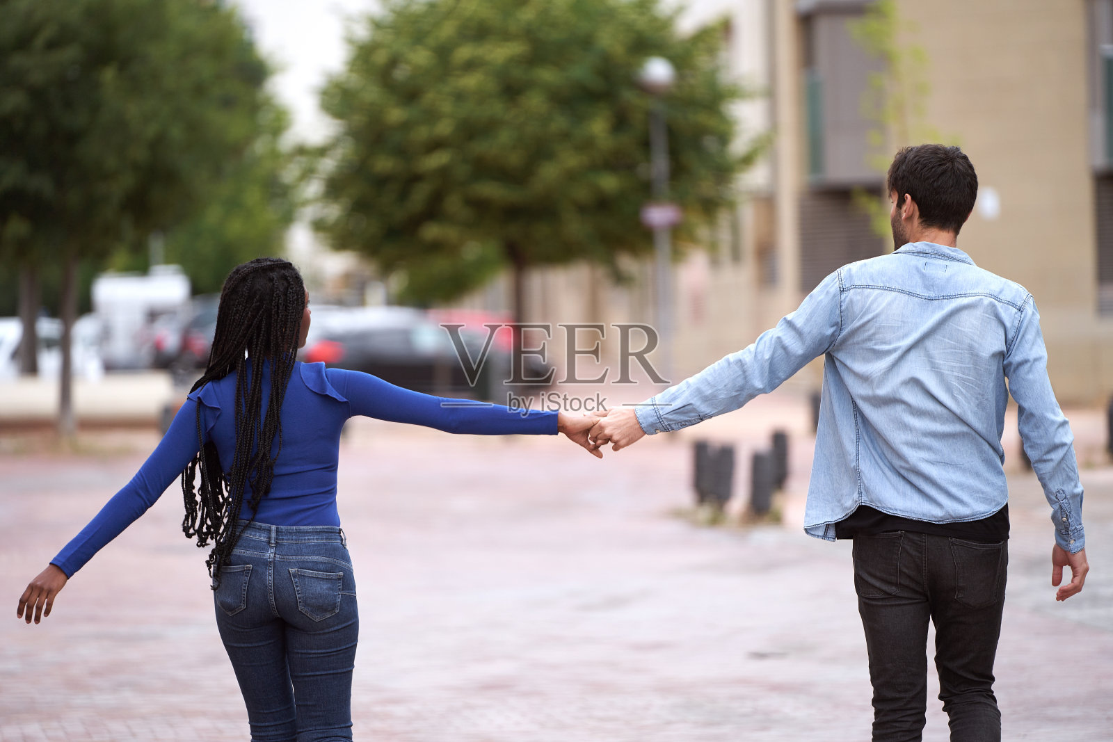 幸福的情侣牵着手一起走在户外。照片摄影图片