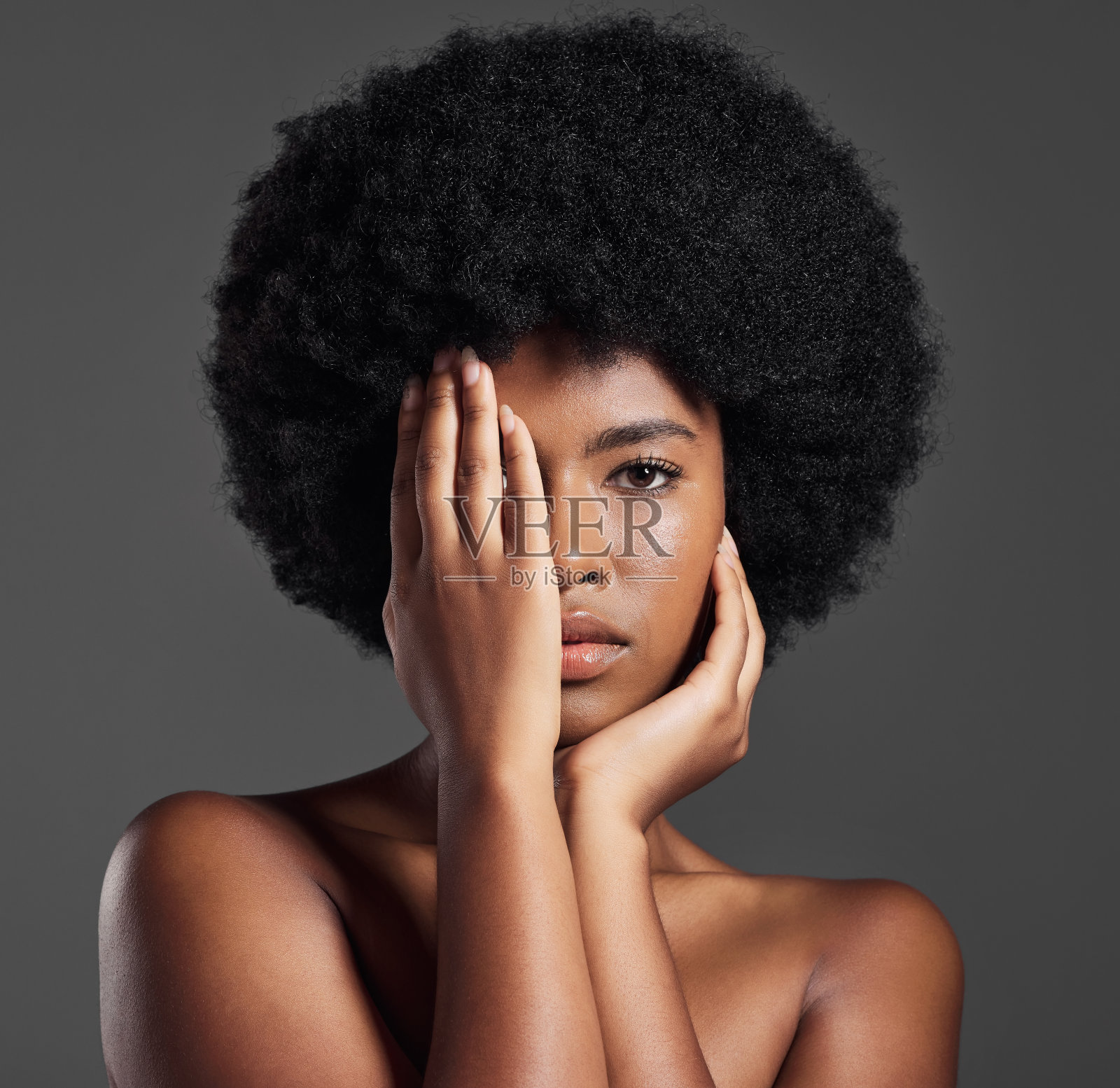 年轻女子在灰色背景前摆姿势的摄影照片摄影图片