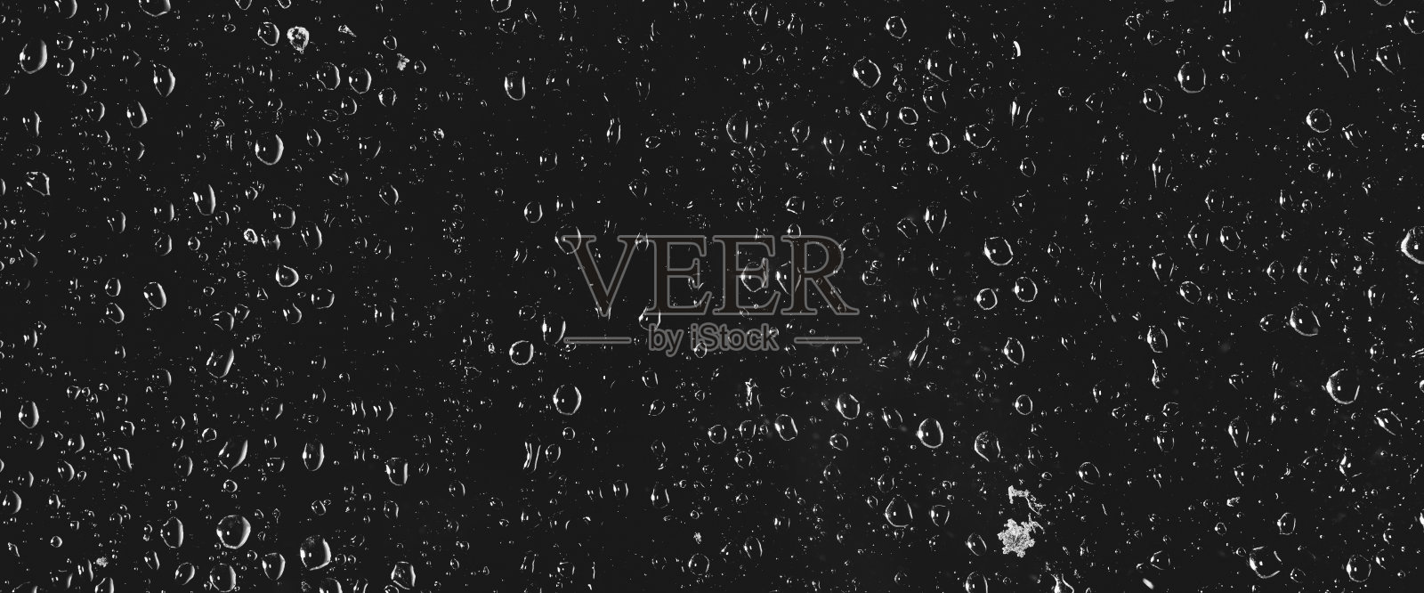 大气最小灰度背景与雨滴在玻璃上。有雨点和污迹的湿窗特写。模糊的极简主义单色背景肮脏的窗户玻璃与雨滴。照片摄影图片