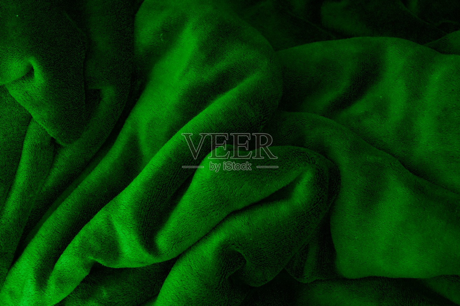 由弯曲成各种形状的织物制成的绿色背景照片摄影图片