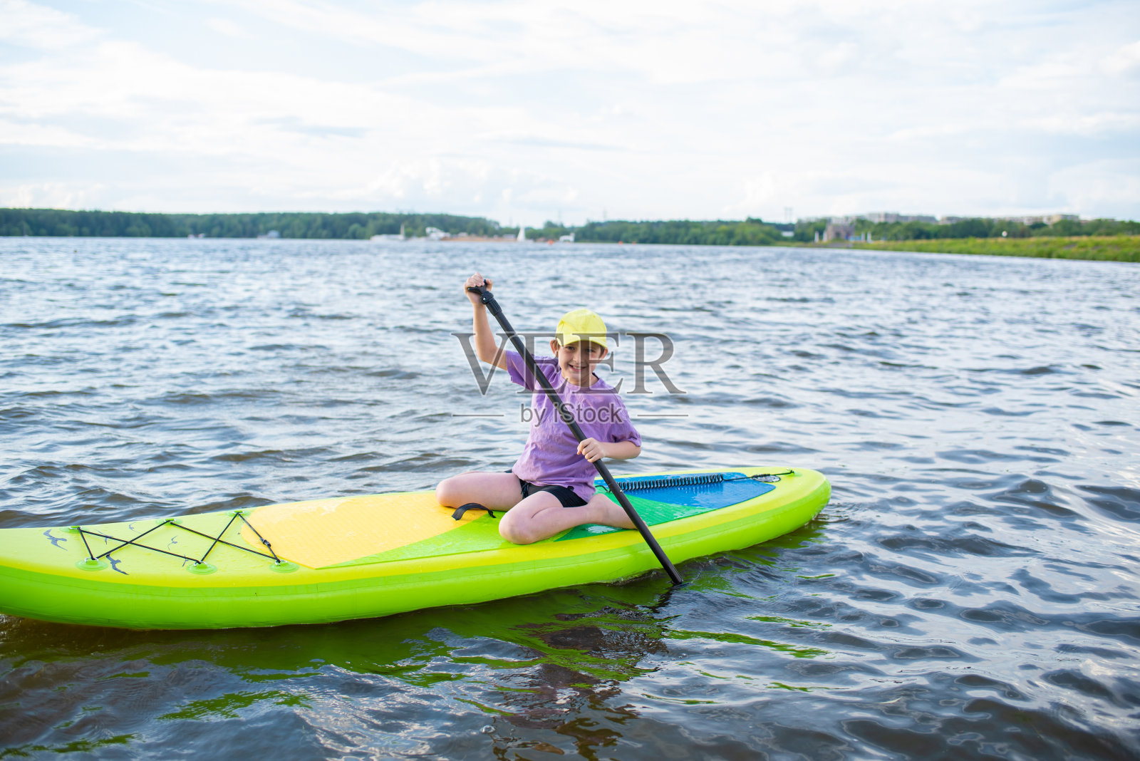 一个10岁的男孩独自在河上或湖上玩SUP板照片摄影图片