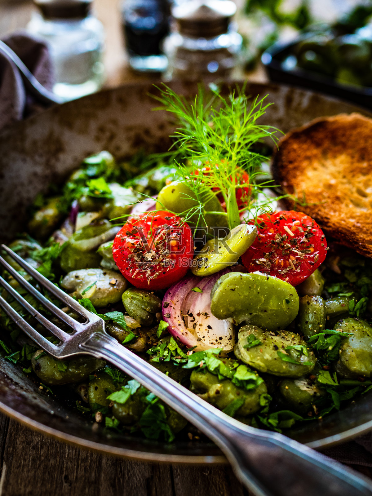 木桌蚕豆沙拉配番茄、洋葱和欧芹照片摄影图片