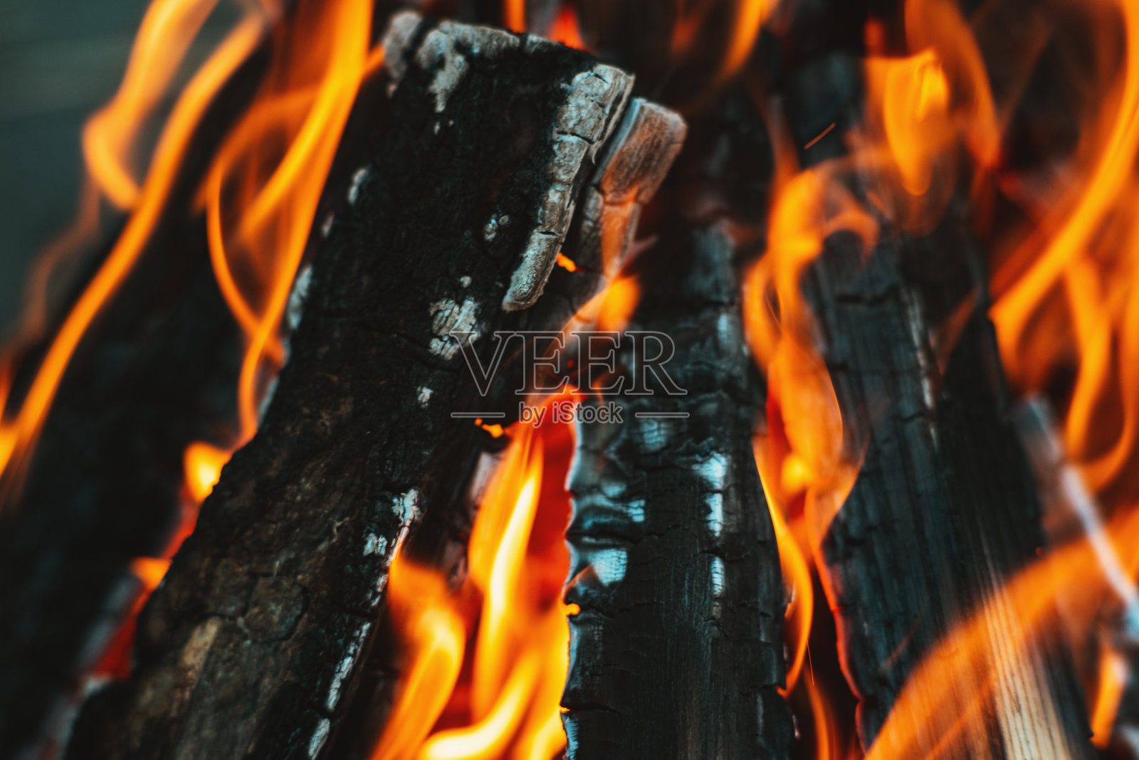 篝火篝火上明亮的火焰堆在金字塔里的木头正在燃烧。火焰特写照片摄影图片