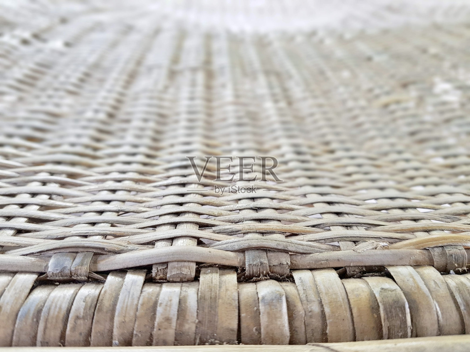 篮子里有一个编织的座位和一个桌子上的木制座位。照片摄影图片