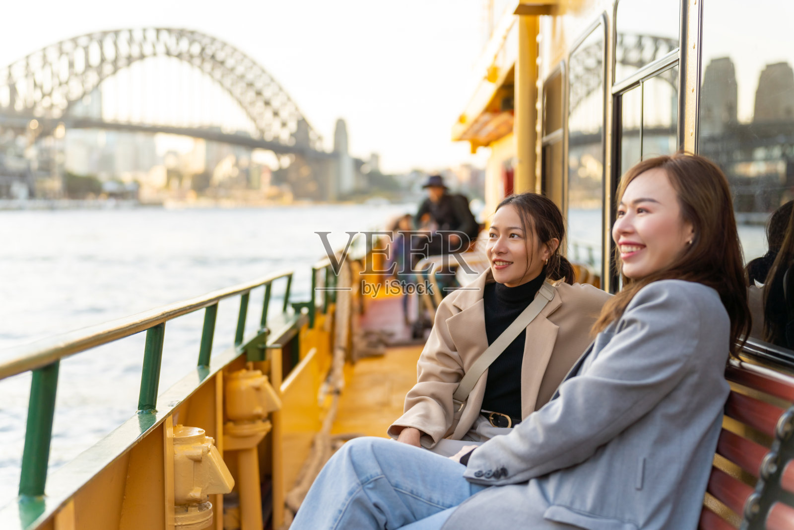亚洲女性朋友乘坐渡轮穿越澳大利亚悉尼港。照片摄影图片