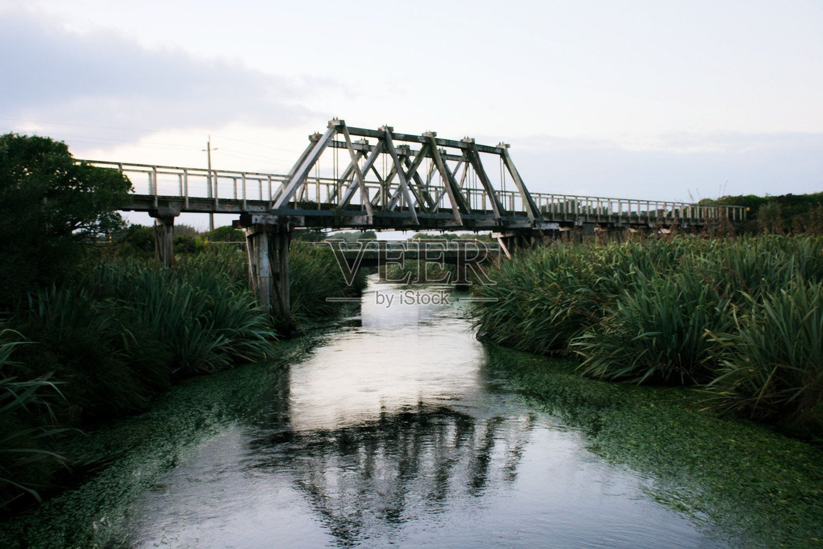 历史悠久的木制铁路桥，横跨新西兰南岛西海岸霍基蒂卡附近的Mahinapua Creek照片摄影图片