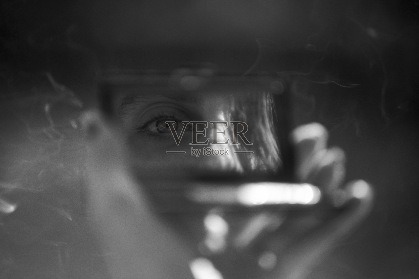 在户外吸烟时看着化妆镜的女人照片摄影图片