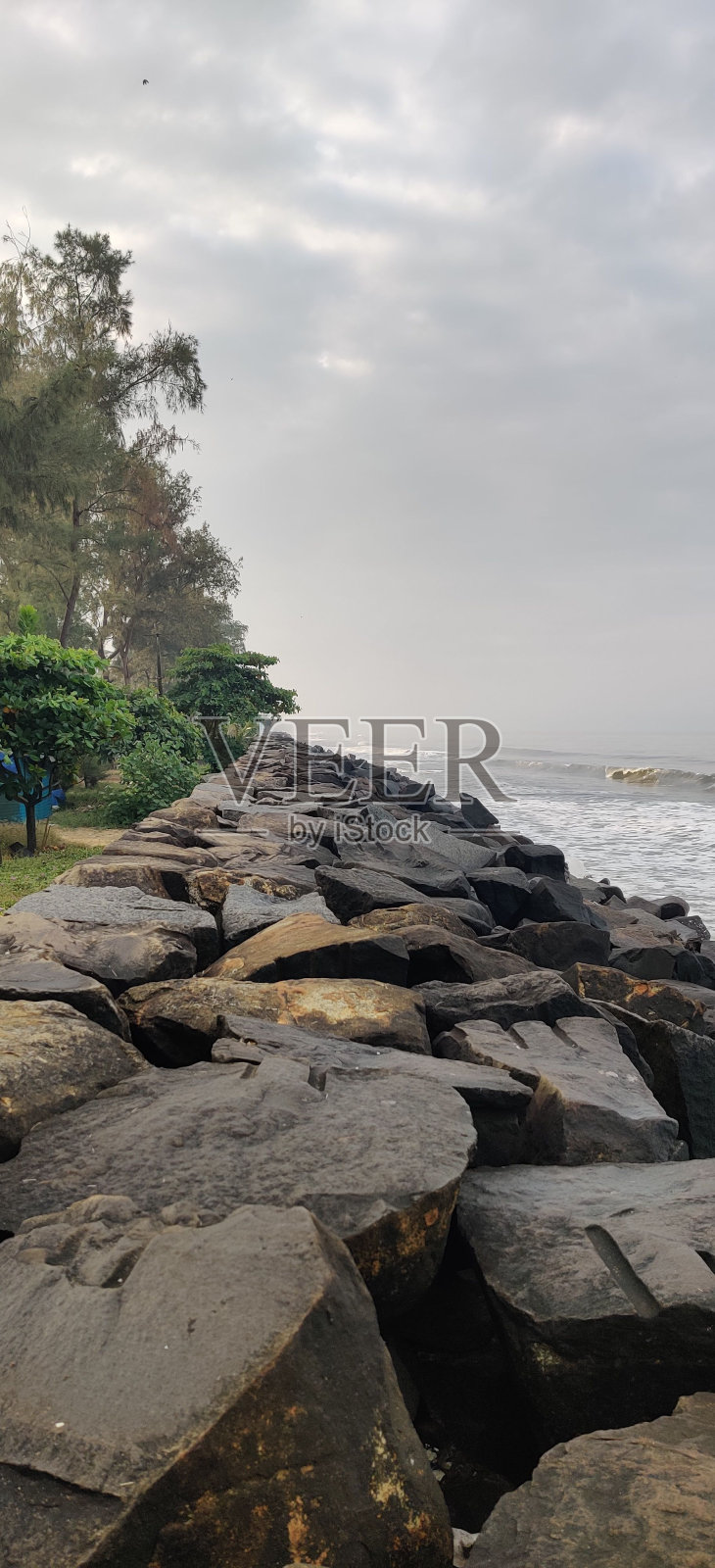 一大片岩石坐落在宁静的水域附近照片摄影图片