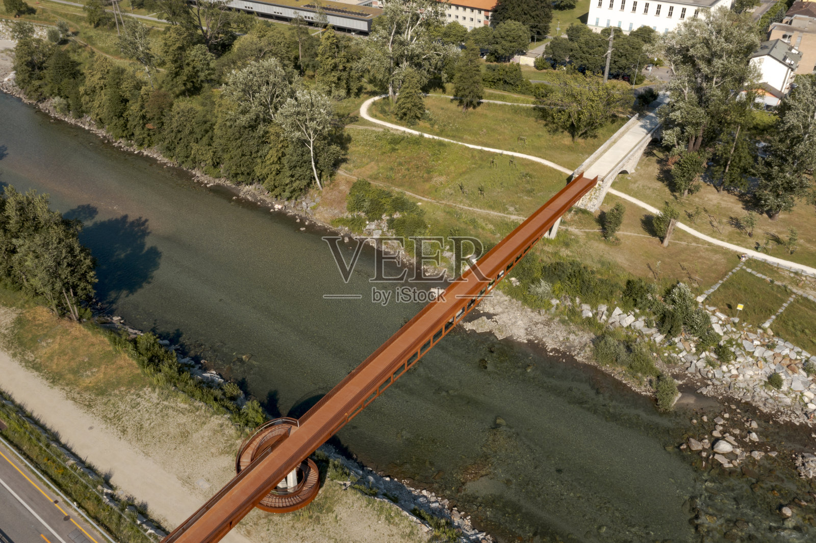 锈迹斑斑的现代步行桥和自行车桥，下面是流淌的提契诺河。美丽的全景阿尔卑斯山的意大利瑞士，从天空中拍摄照片摄影图片