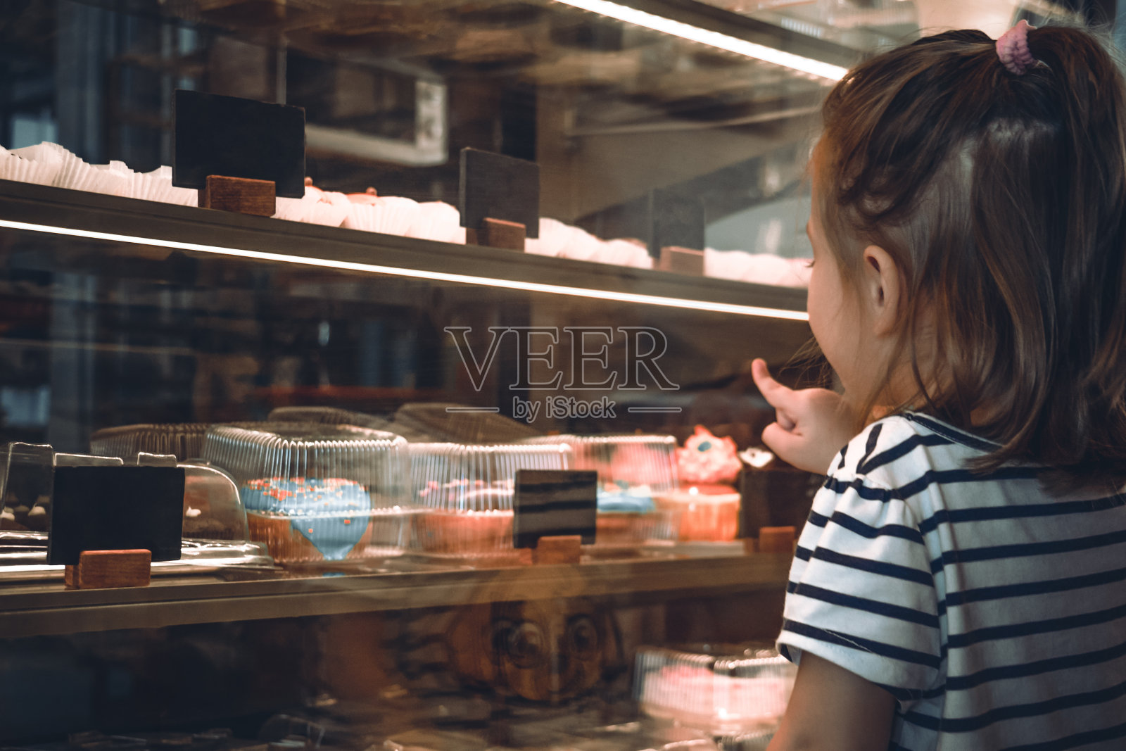 快乐的小女孩在咖啡厅选择甜点照片摄影图片