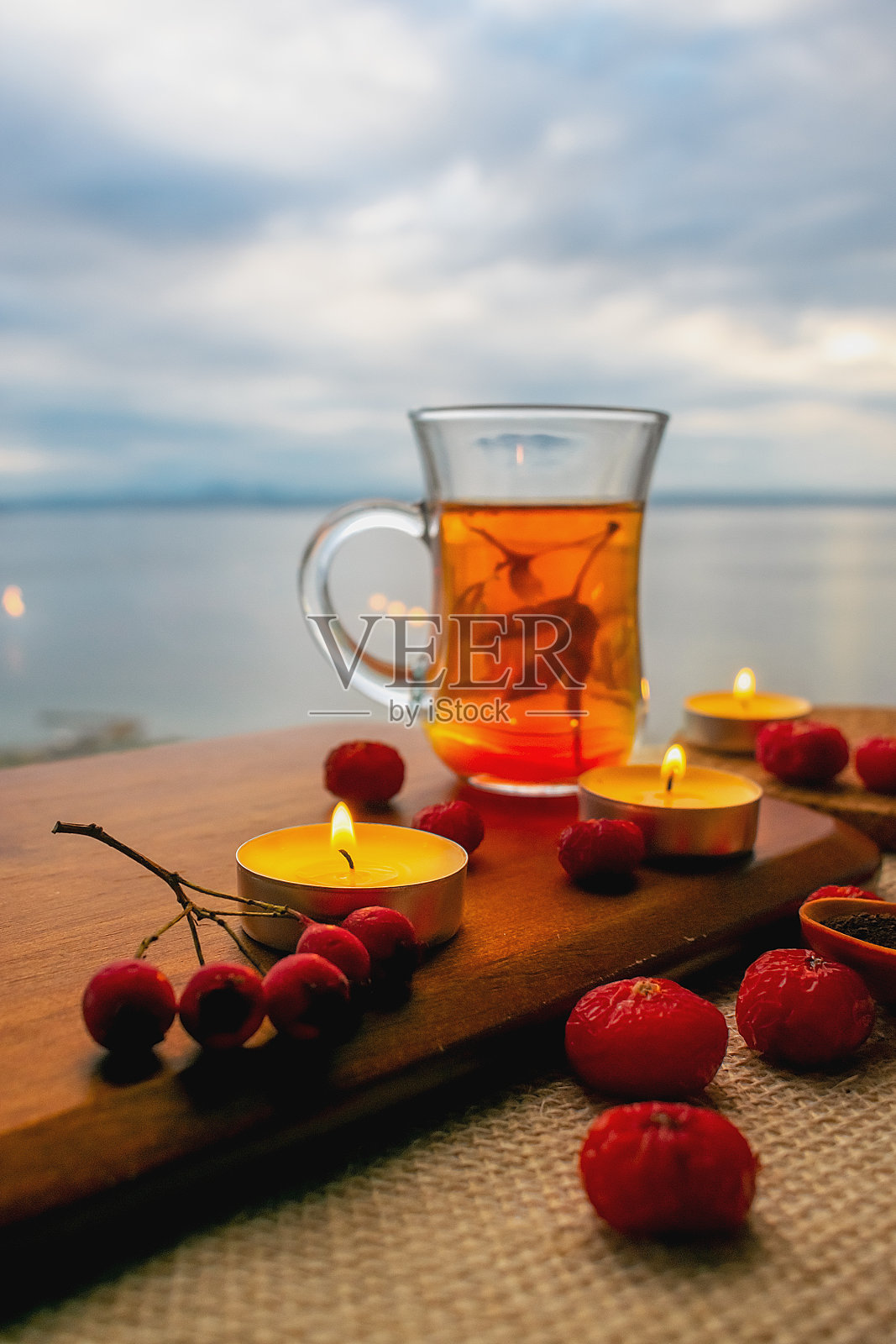 在多云天空的背景下，红茶和玫瑰果照片摄影图片