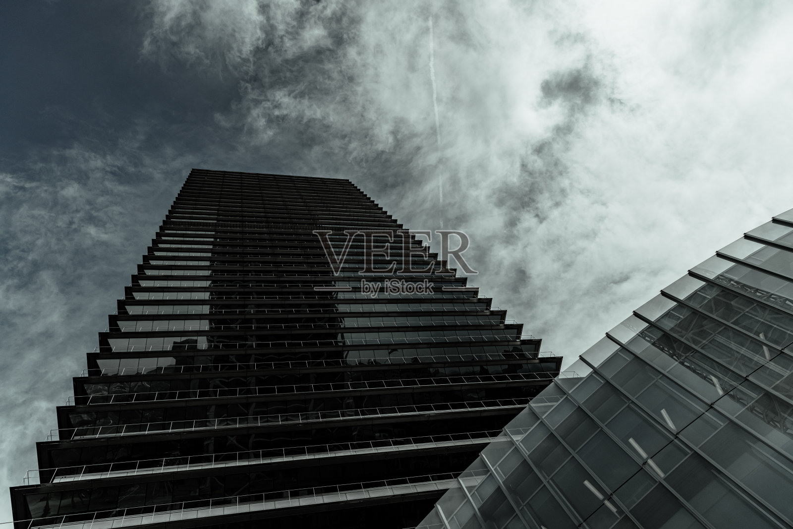 从下面俯瞰西班牙巴塞罗那的几何摩天大楼，有棱角的边缘和镜像的墙壁照片摄影图片