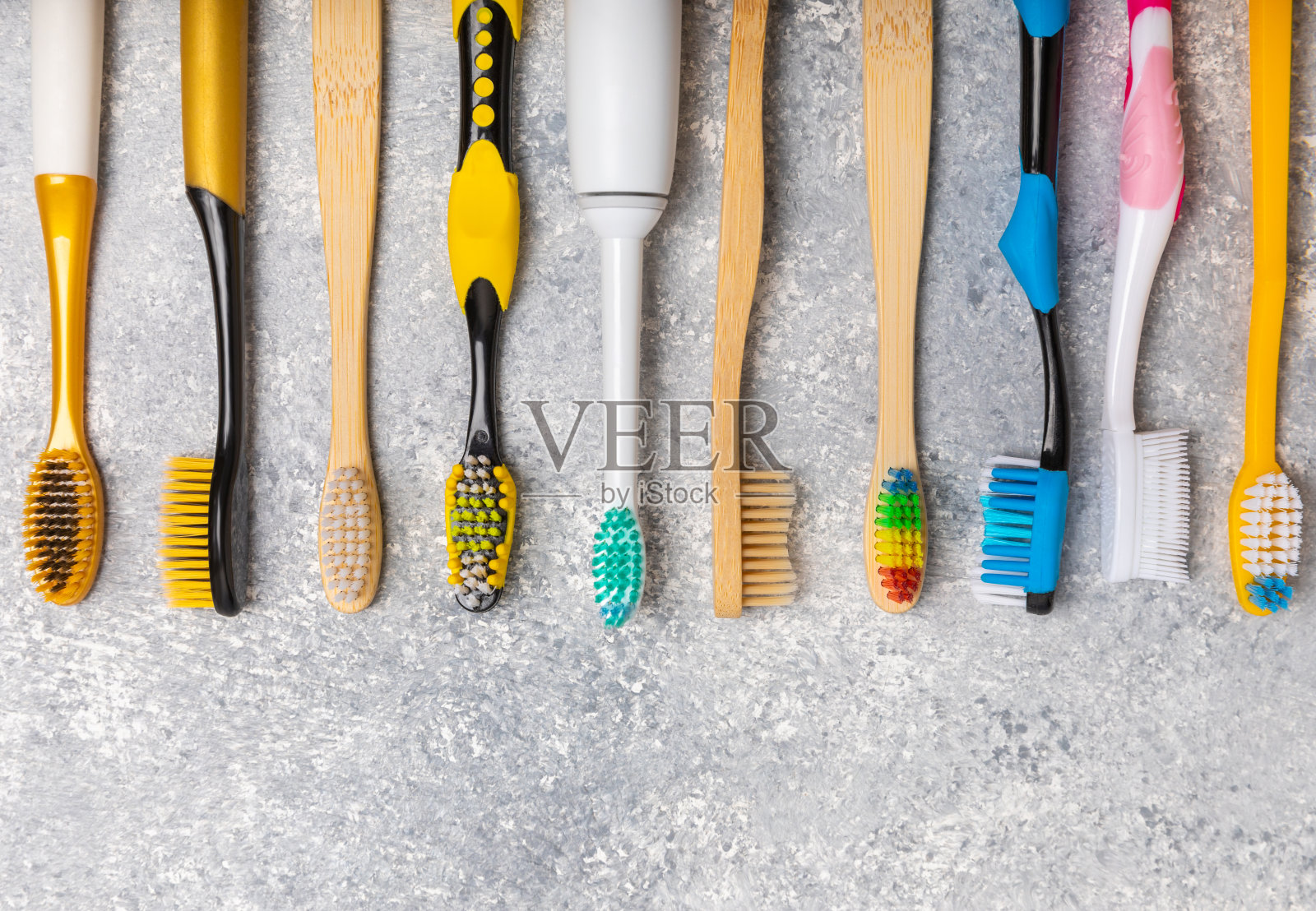 大理石背景的电动和手动牙刷。从上面看。口腔卫生。普通牙刷，生态牙刷和电动牙刷。口腔卫生。口腔护理包。牙医的概念。牙科保健。照片摄影图片
