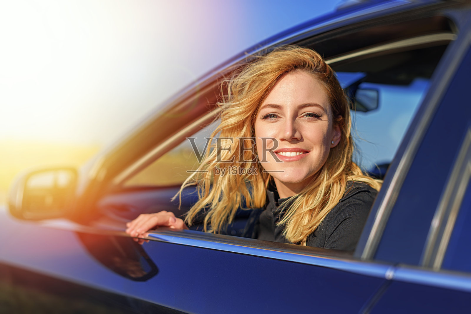 开着车的金发美女。照片摄影图片