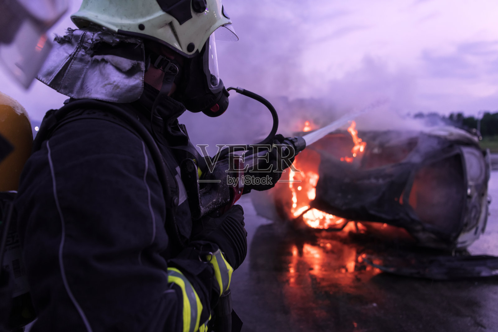 消防队员与火焰搏斗以控制火势不向外蔓延。消防员的工业和公共安全理念。交通或汽车事故的救援和帮助行动。照片摄影图片