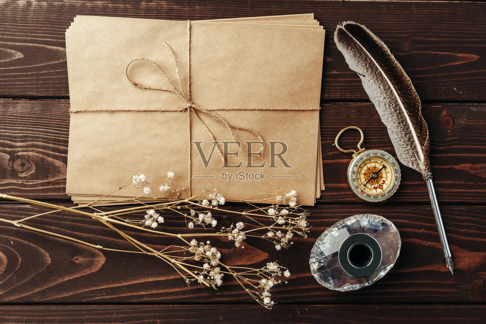 一张旧纸的顶视图，棕色的木质纹理背景与羽毛照片摄影图片