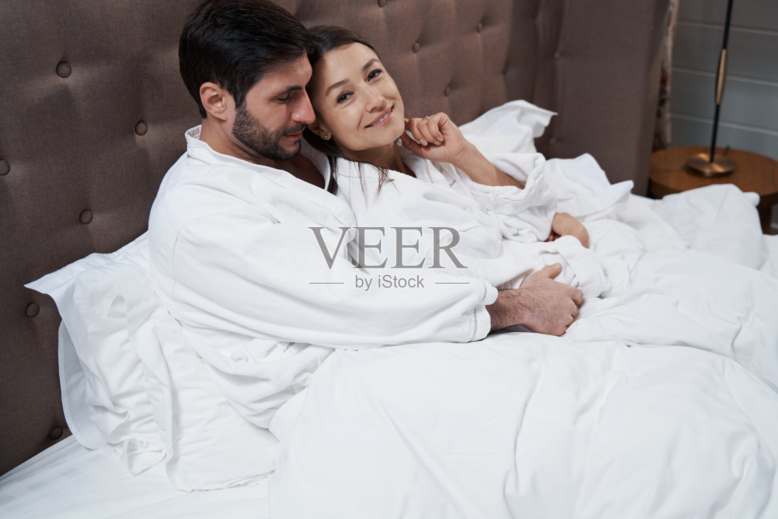 躺在床上靠在丈夫肩膀上的女人照片摄影图片