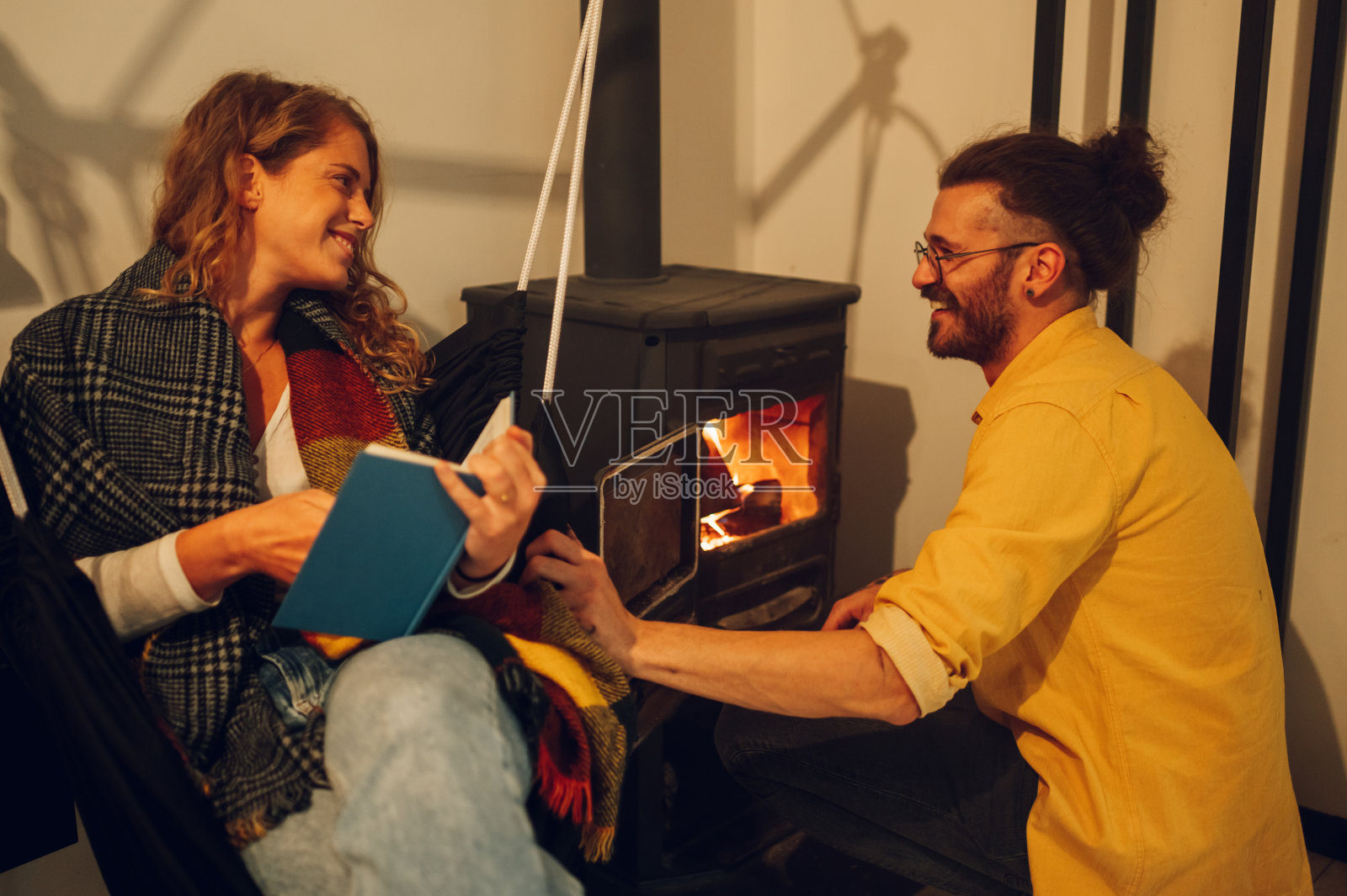 一对幸福的夫妇一起在舒适的小屋度过冬天的周末。照片摄影图片