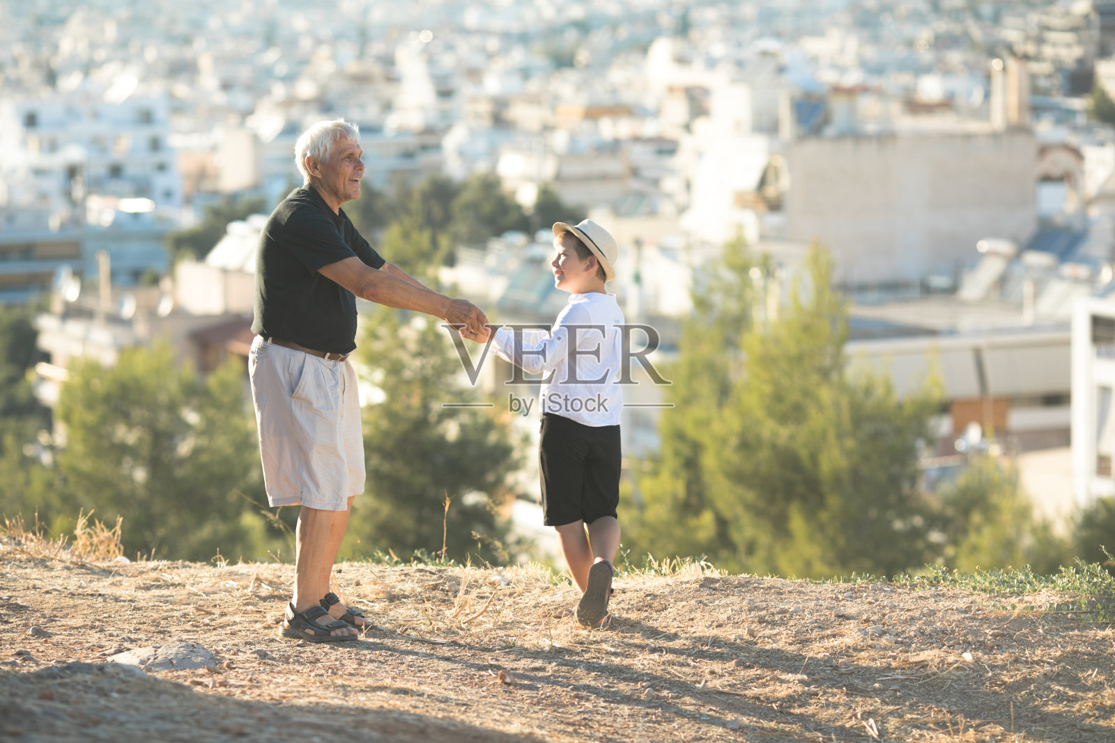 老人和年轻人。家庭世代与关系观念。退休的爷爷和孙子在阳光明媚的日子里玩耍，享受户外的乐趣。照片摄影图片