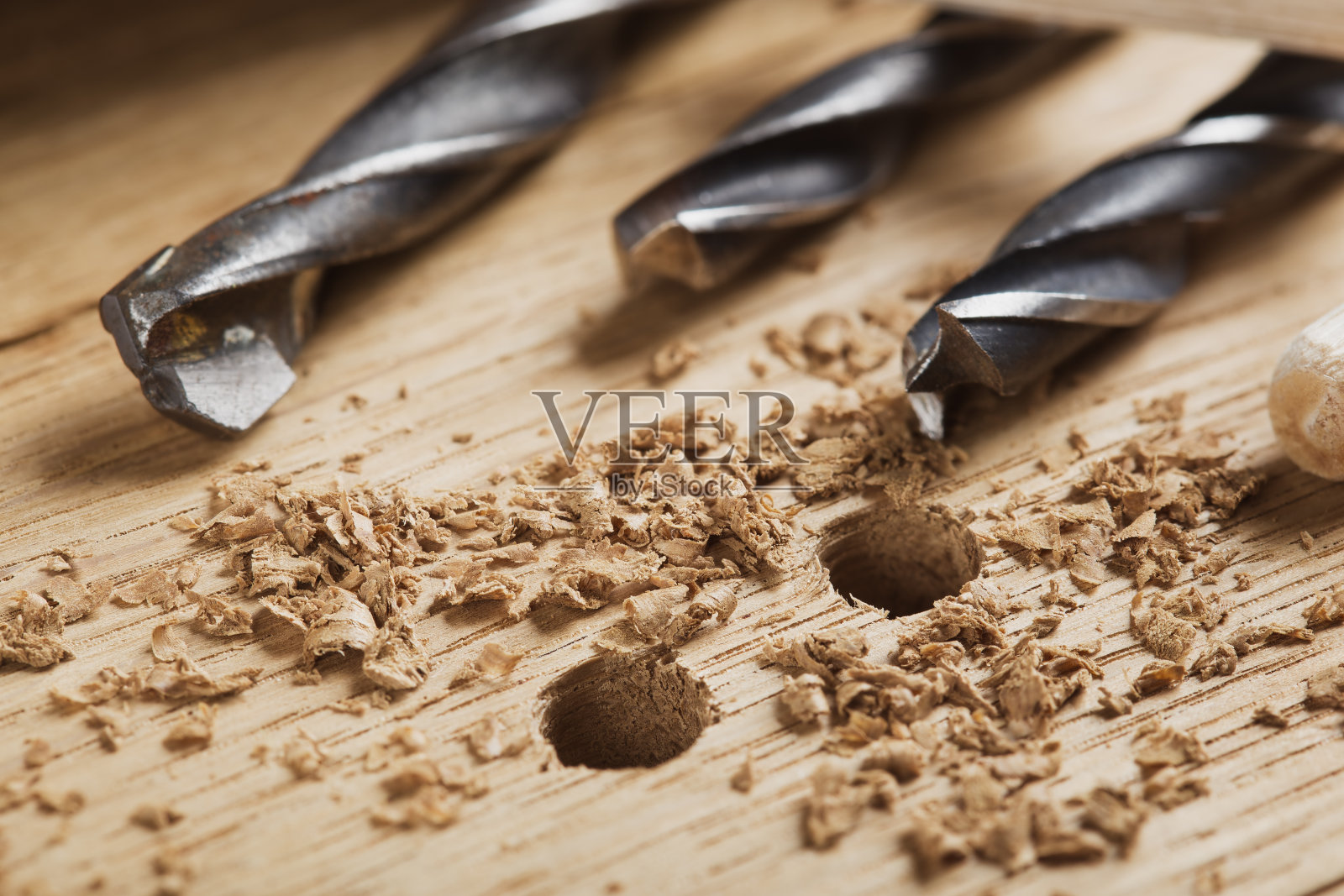 用于木销子的木橡木板上的孔。木工行业。照片摄影图片