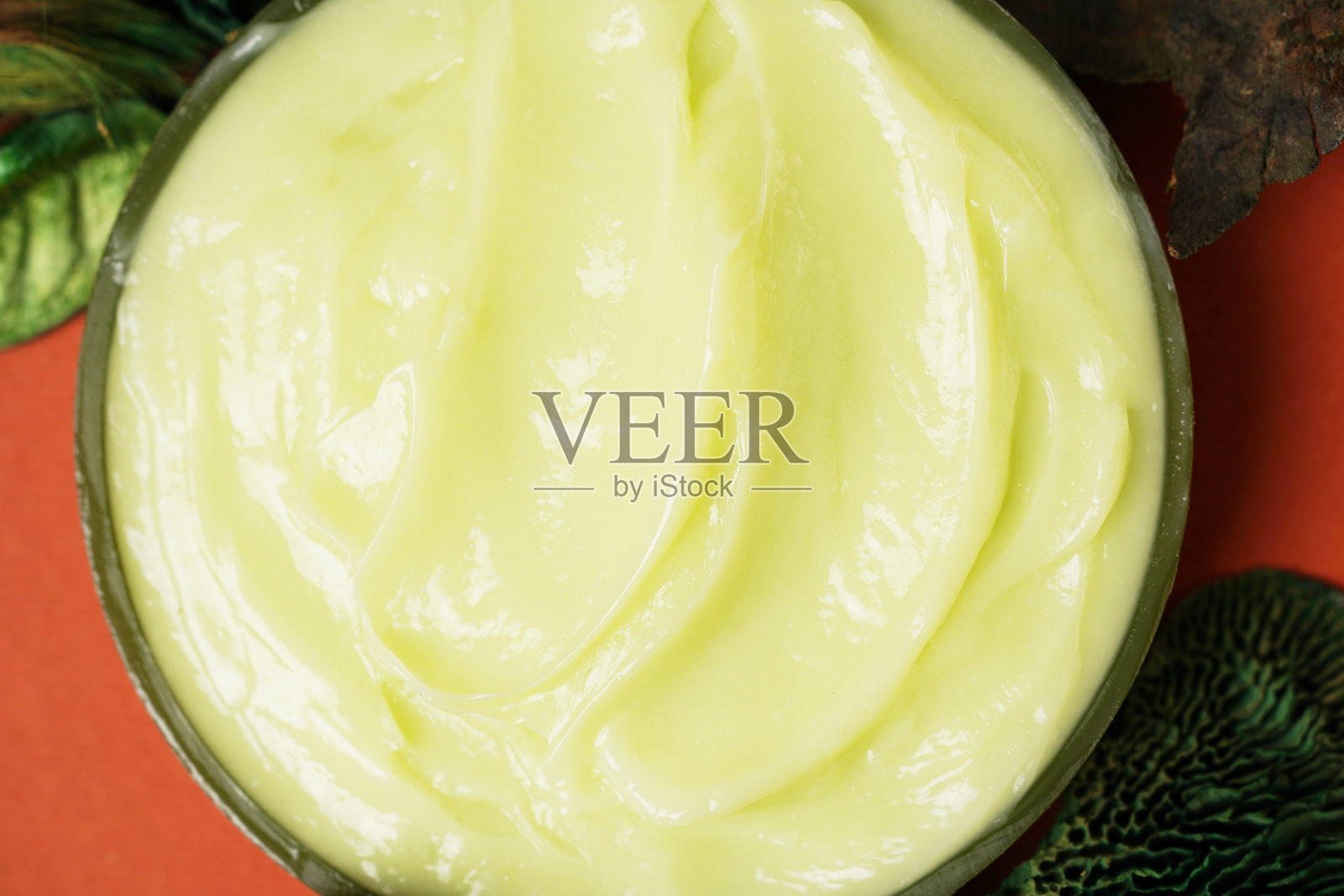 绿色叶子上的天然护肤霜的纹理。来自植物的天然有机化妆品，用于皮肤护理照片摄影图片