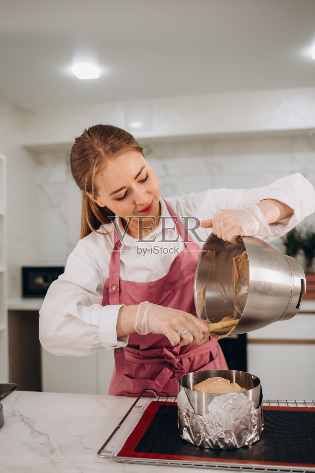 一个女人正在厨房里准备芝士蛋糕照片摄影图片