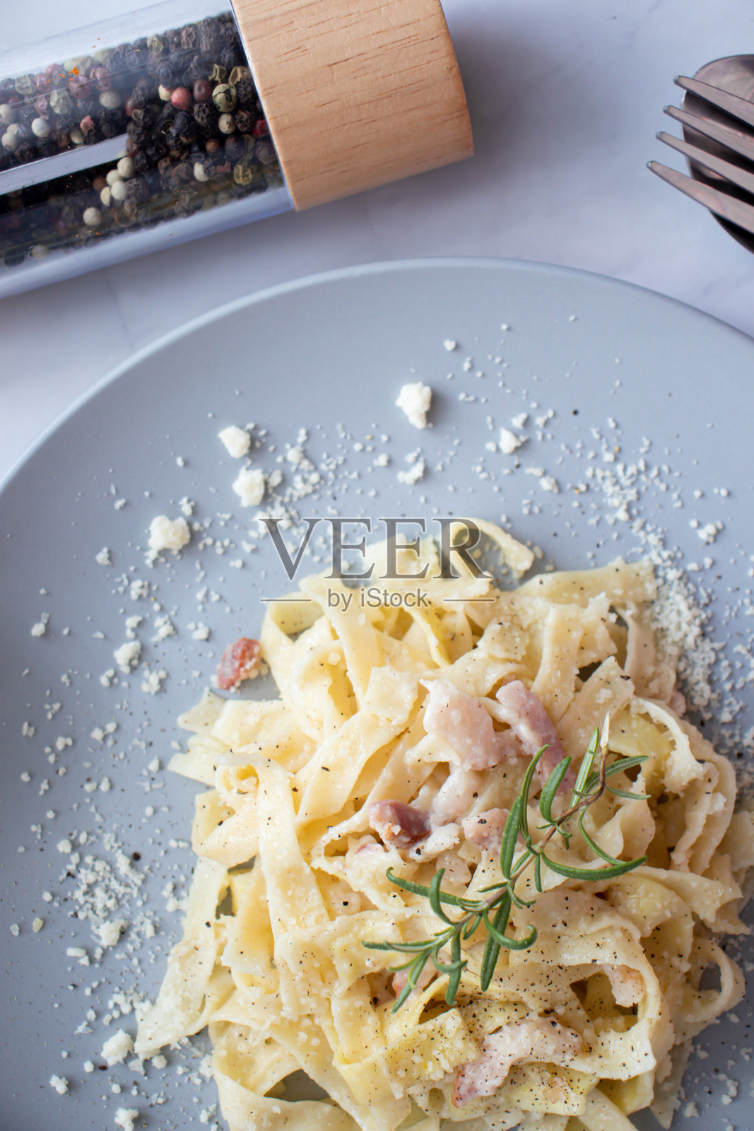 自制意大利宽面条配白奶油酱。意大利宽面，硬奶酪，干猪肉，黑胡椒。意大利菜。照片摄影图片