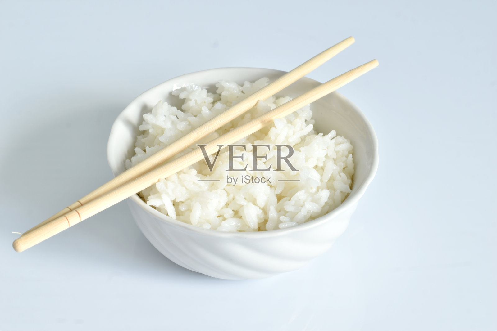 用杯子和棍子煮米饭。照片摄影图片