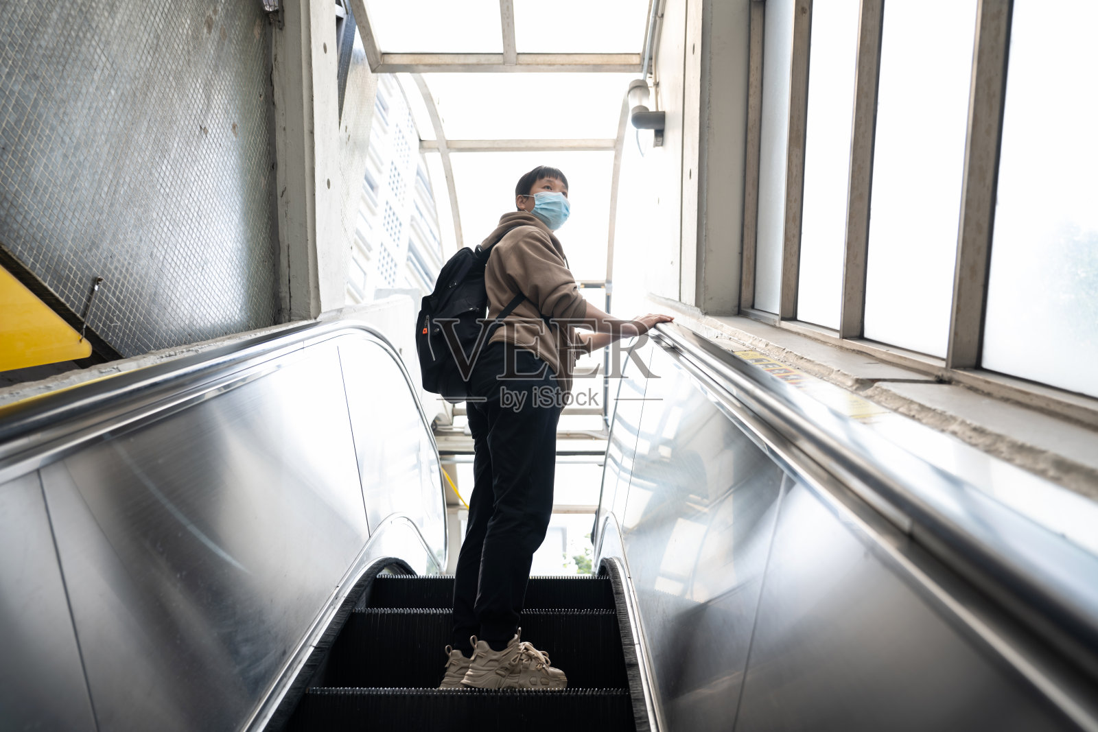 一位女游客正在乘坐公共自动扶梯照片摄影图片