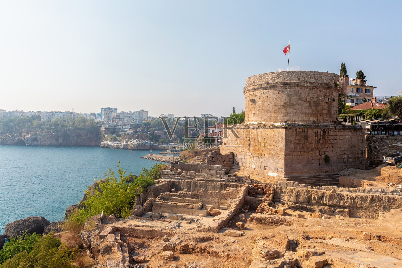 希德利克塔，公元2世纪罗马堡垒的一部分，前方是考古发掘。海湾和现代安塔利亚的景观为背景。旅游和历史的概念。土耳其安塔利亚照片摄影图片