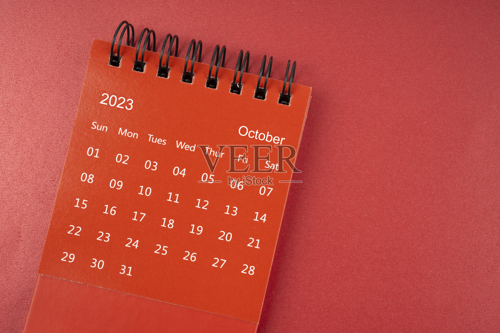 2023年10月的红色台历，供组织者在红色背景上进行计划和提醒。照片摄影图片