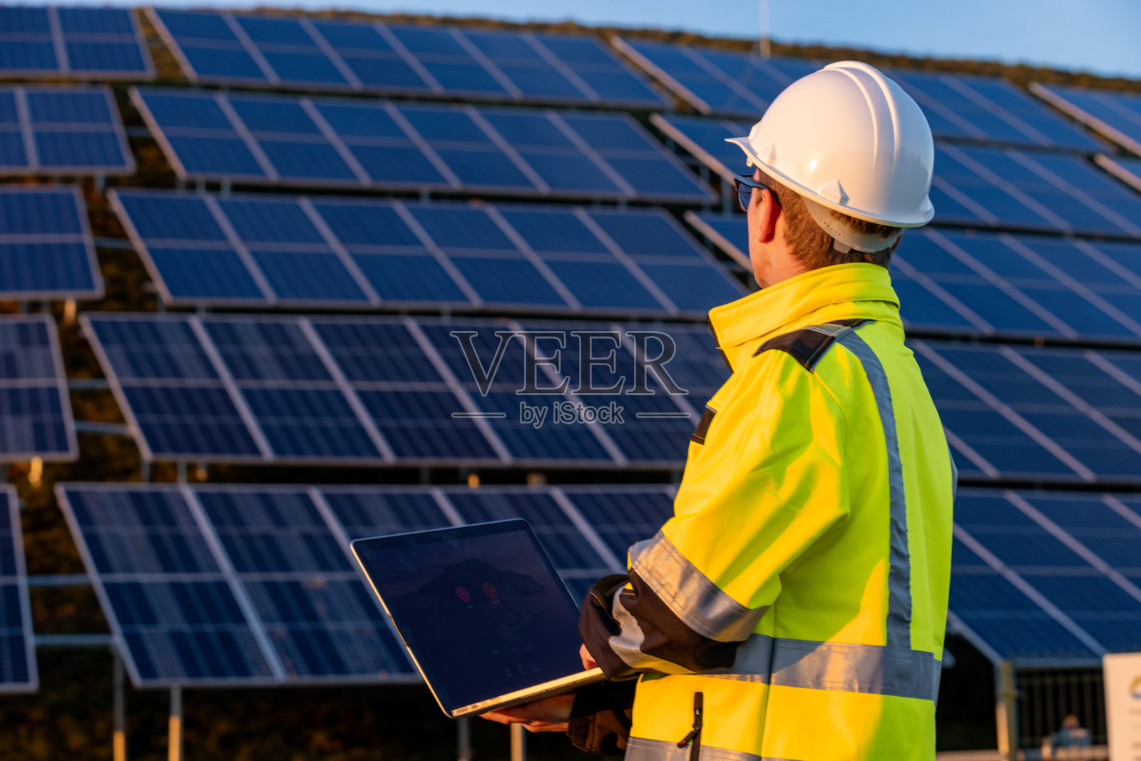 一名工程师使用笔记本电脑维护太阳能电池板照片摄影图片