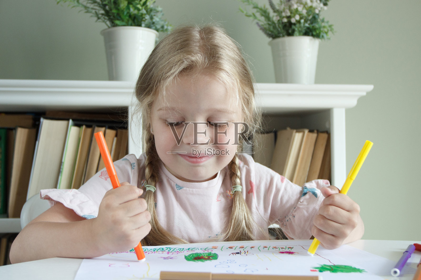 可爱的孩子在用彩色毡尖笔画画。爱好的概念照片摄影图片