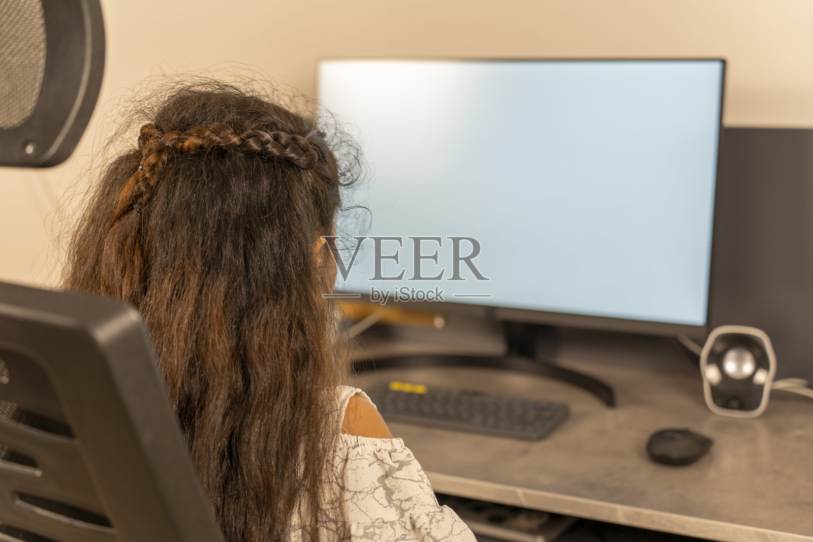 在电脑桌前学习的小女孩。照片摄影图片