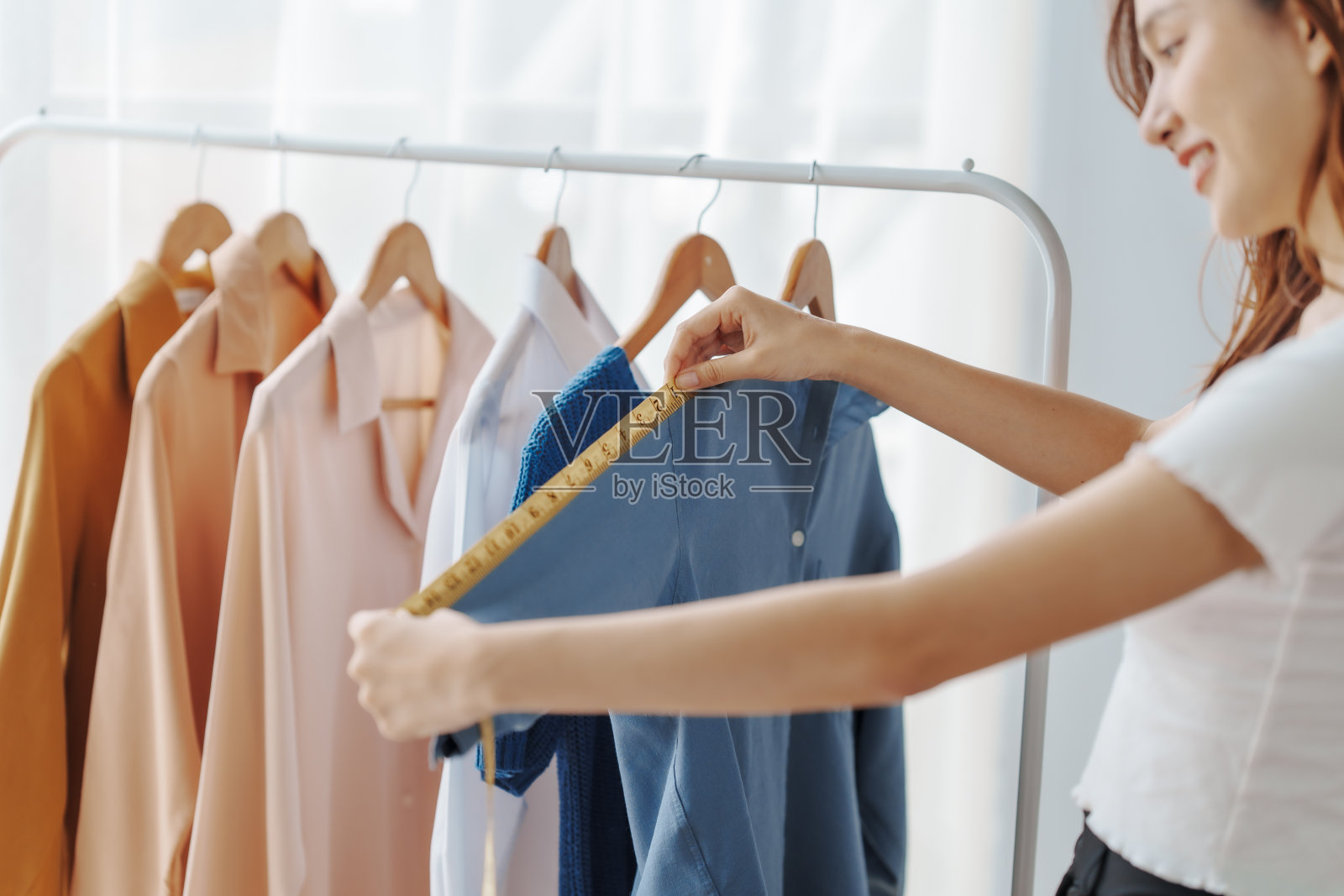 如何在网上开一家服装店经营服装!年轻自信的亚洲女性时尚老板社交媒体网红现场卖衣服，新产品在家办公小生意电商。照片摄影图片