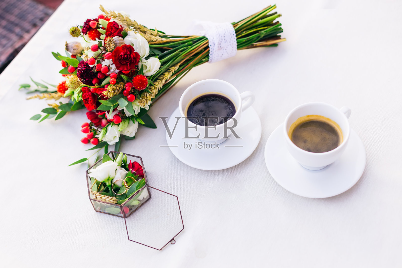 婚礼花束，一盒戒指和两杯热咖啡。照片摄影图片