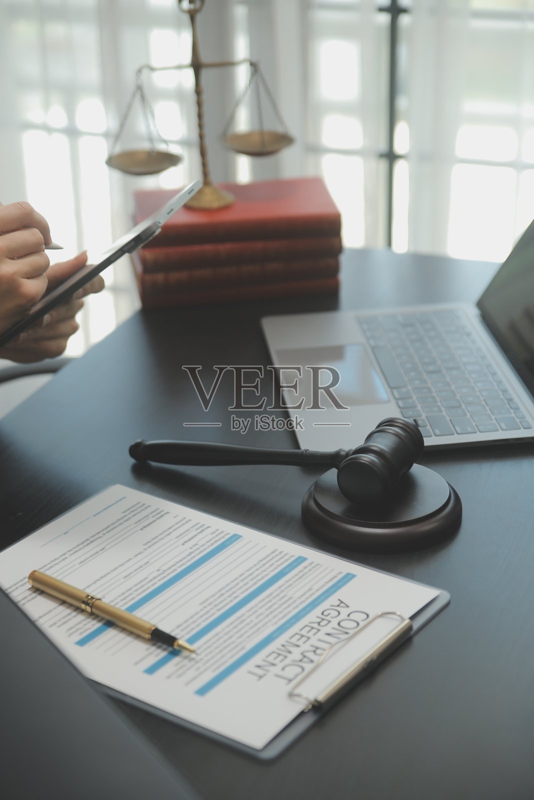 商务人士和律师们在办公室的桌子上用黄铜秤讨论合同文件。法律、法律服务、法律咨询、司法和法律概念图片具有膜纹效果照片摄影图片