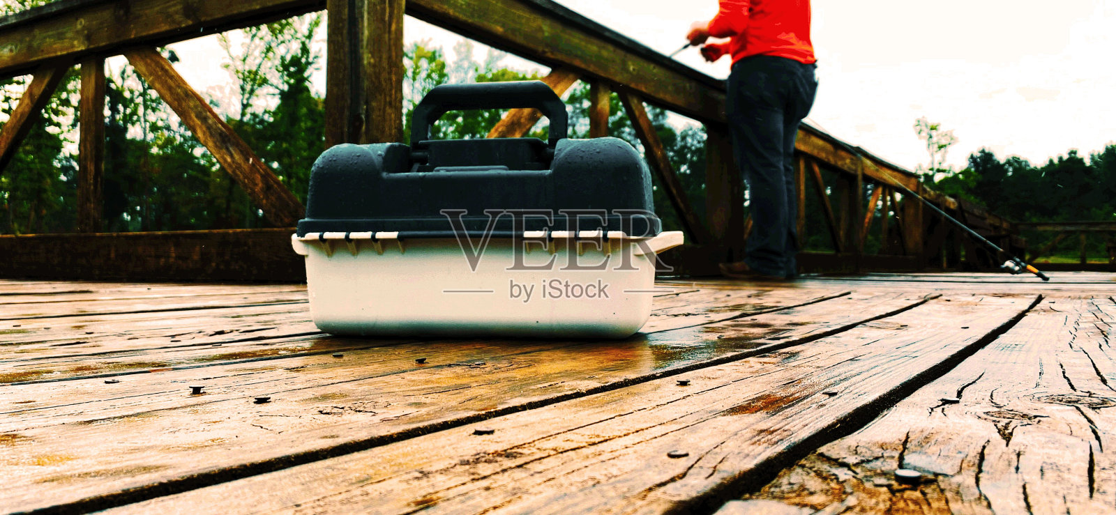 钓具盒与男子钓鱼的背景照片摄影图片