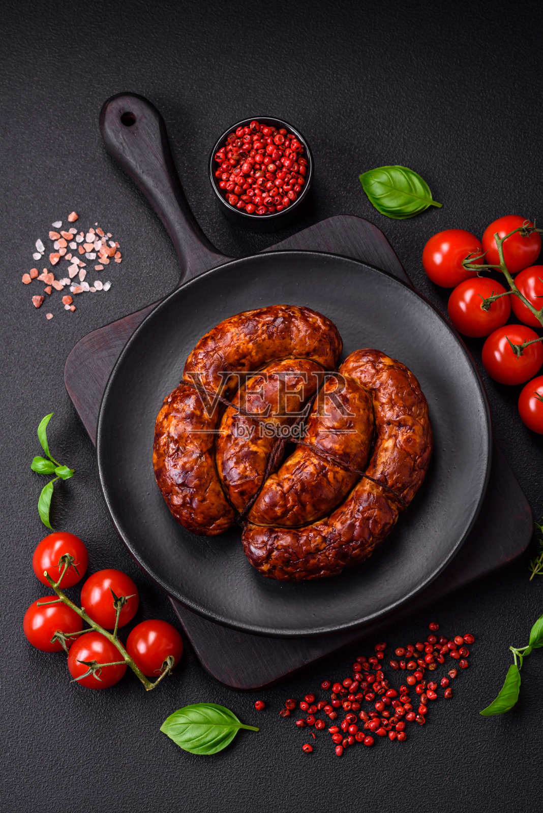 美味的烤香肠，配上盐、香料和香草照片摄影图片