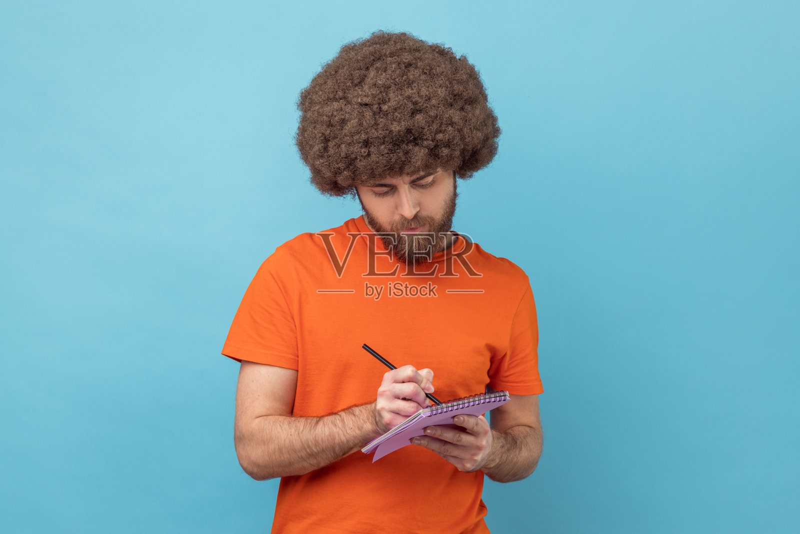 男人在纸质笔记本上做笔记，写下经营理念，未来计划，核对约会。照片摄影图片