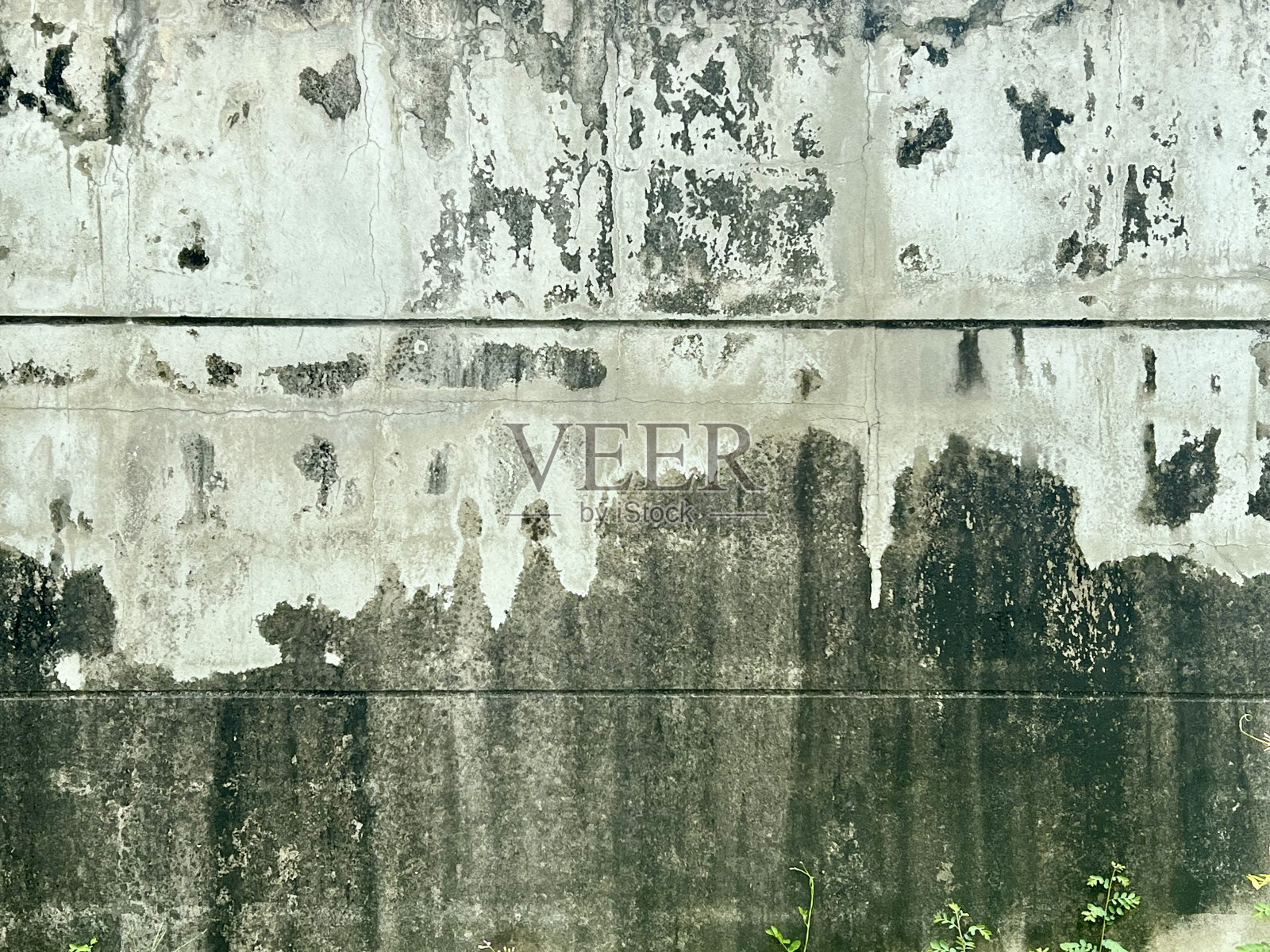 一张照片上，一个消防栓在一堵油漆剥落的墙上，坐在一张长凳上，在一堵涂鸦的墙上照片摄影图片