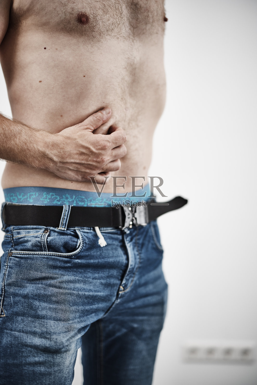 男性抱着肚子疼照片摄影图片