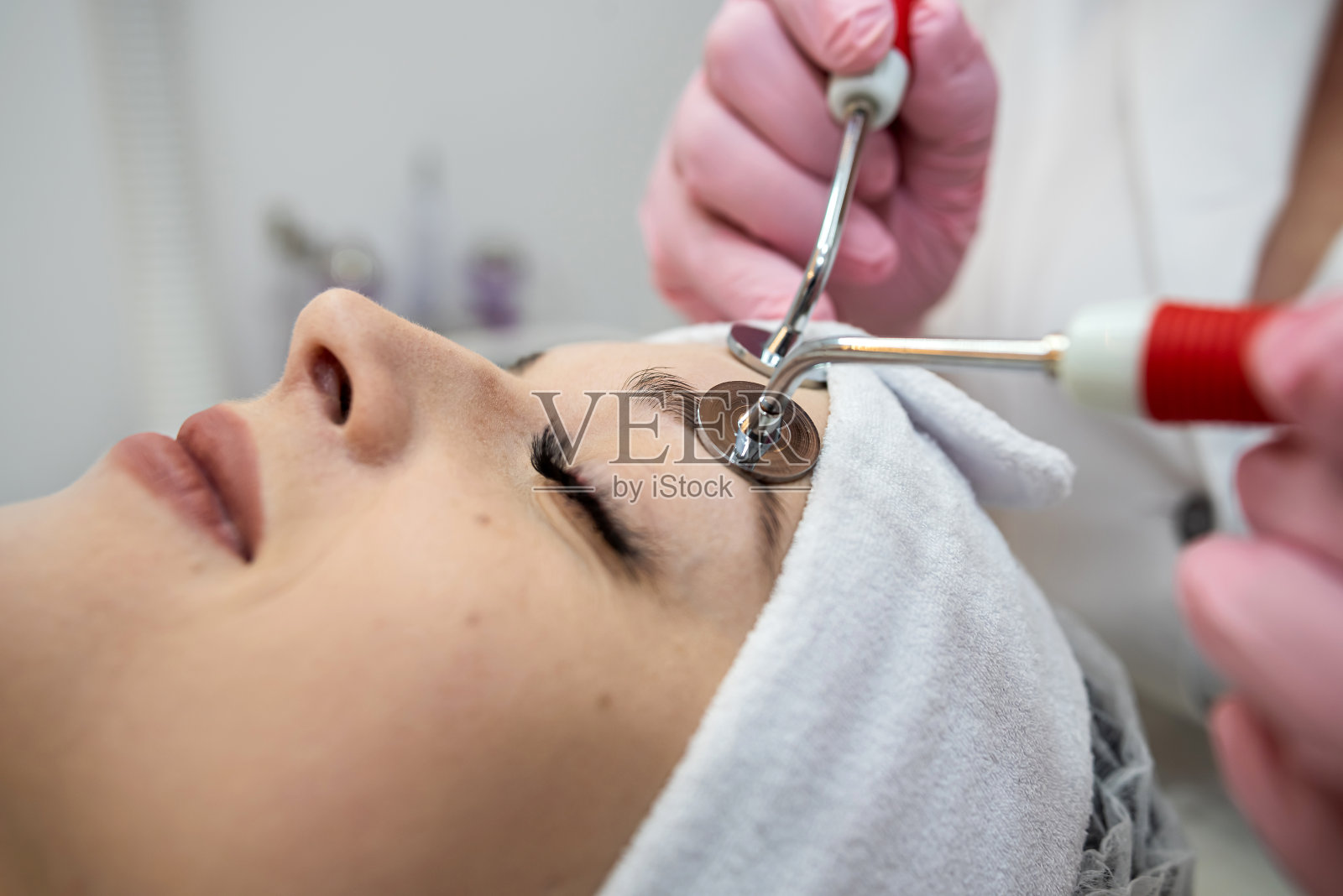 年轻漂亮的女子在水疗诊所接受面部微电流刺激治疗照片摄影图片