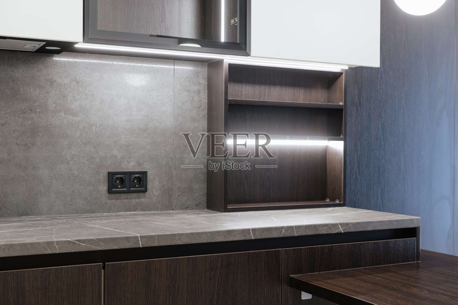 灰色的桌面，白色的立面和照明，在新厨房照片摄影图片