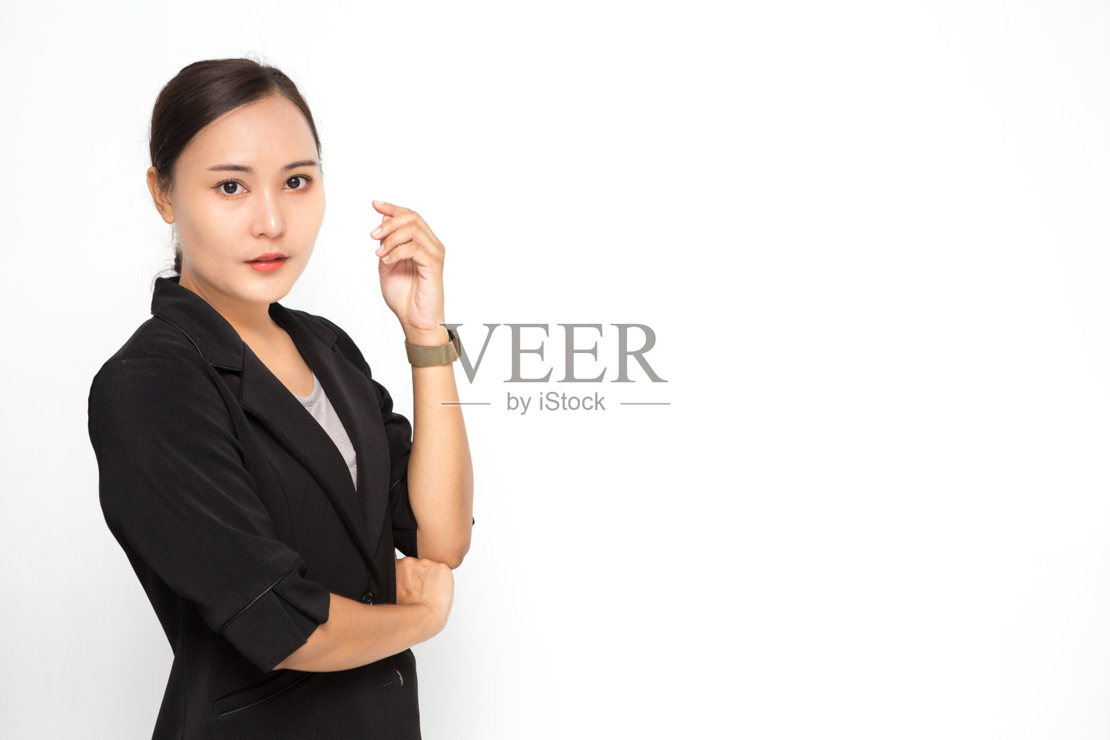 美丽的亚洲商业女性穿着黑色西装与她交叉的手臂在白色背景和拷贝空间。自信的亚洲职业女性微笑，开朗照片摄影图片