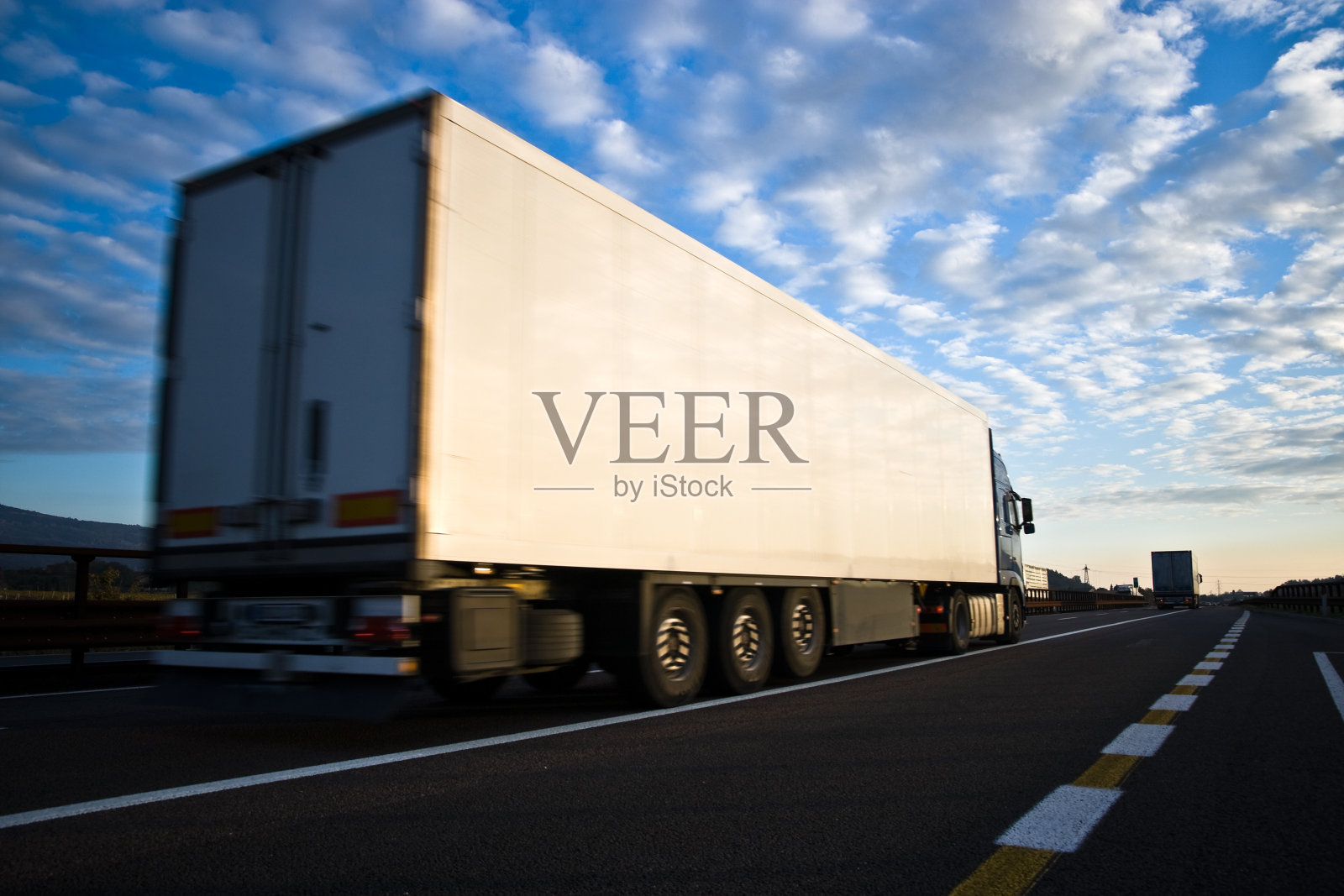 在蓝天下的高速公路上行驶的卡车照片摄影图片