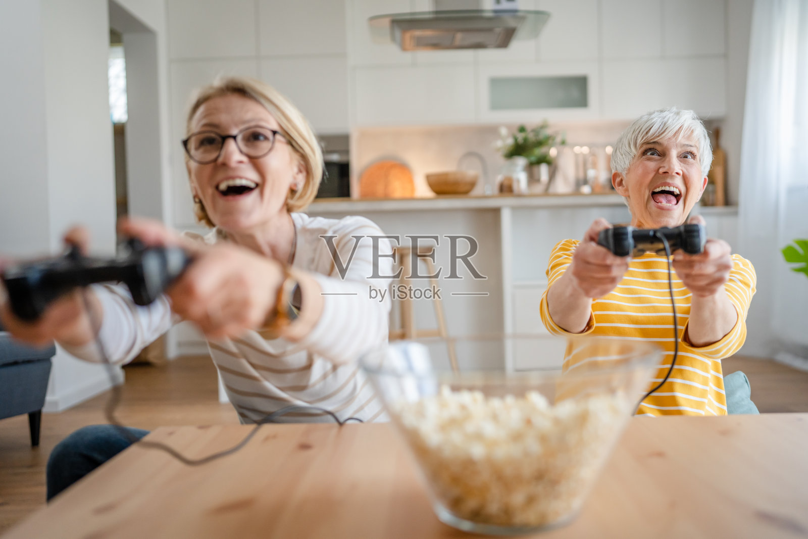 两个年长的女性白人朋友或姐妹在玩游戏机电子游戏照片摄影图片